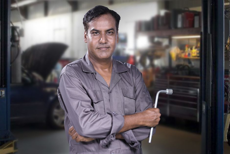 Friendly auto glass technician inspecting a vehicle window