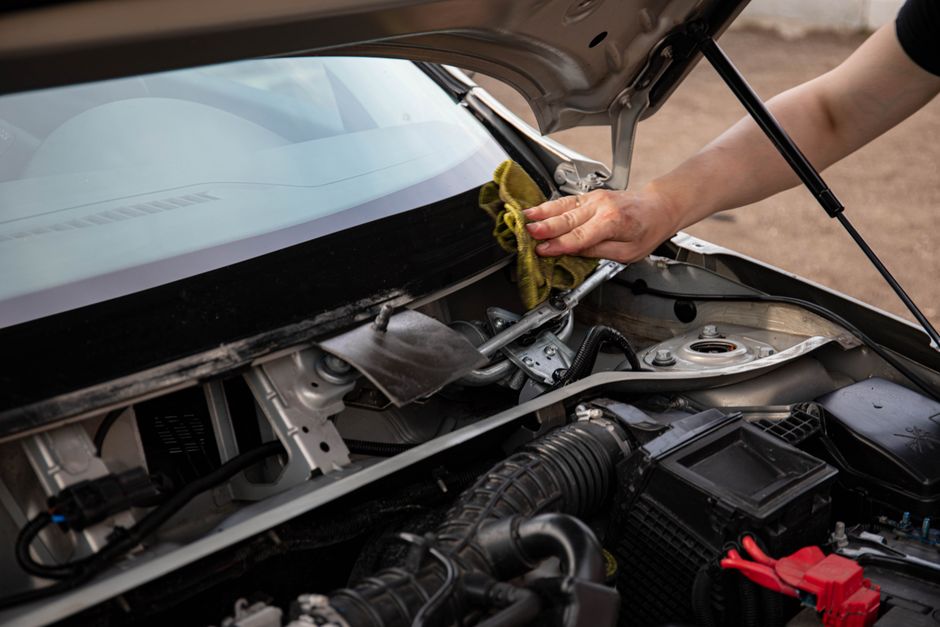 Mechanic replacing a car windshield in a professional garage setting